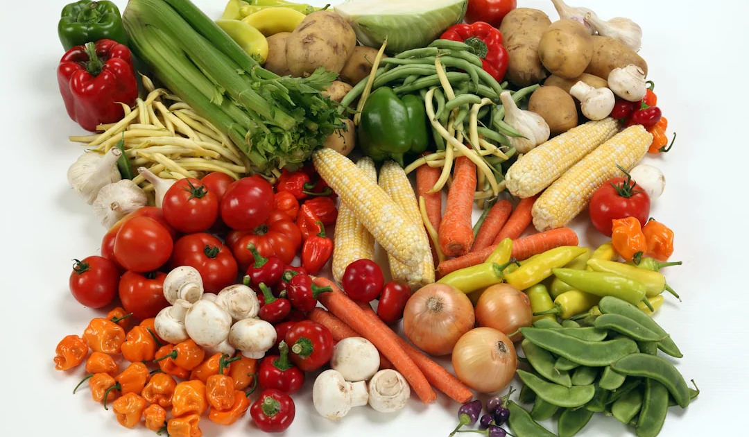a pile of different types of vegetables on a white surface